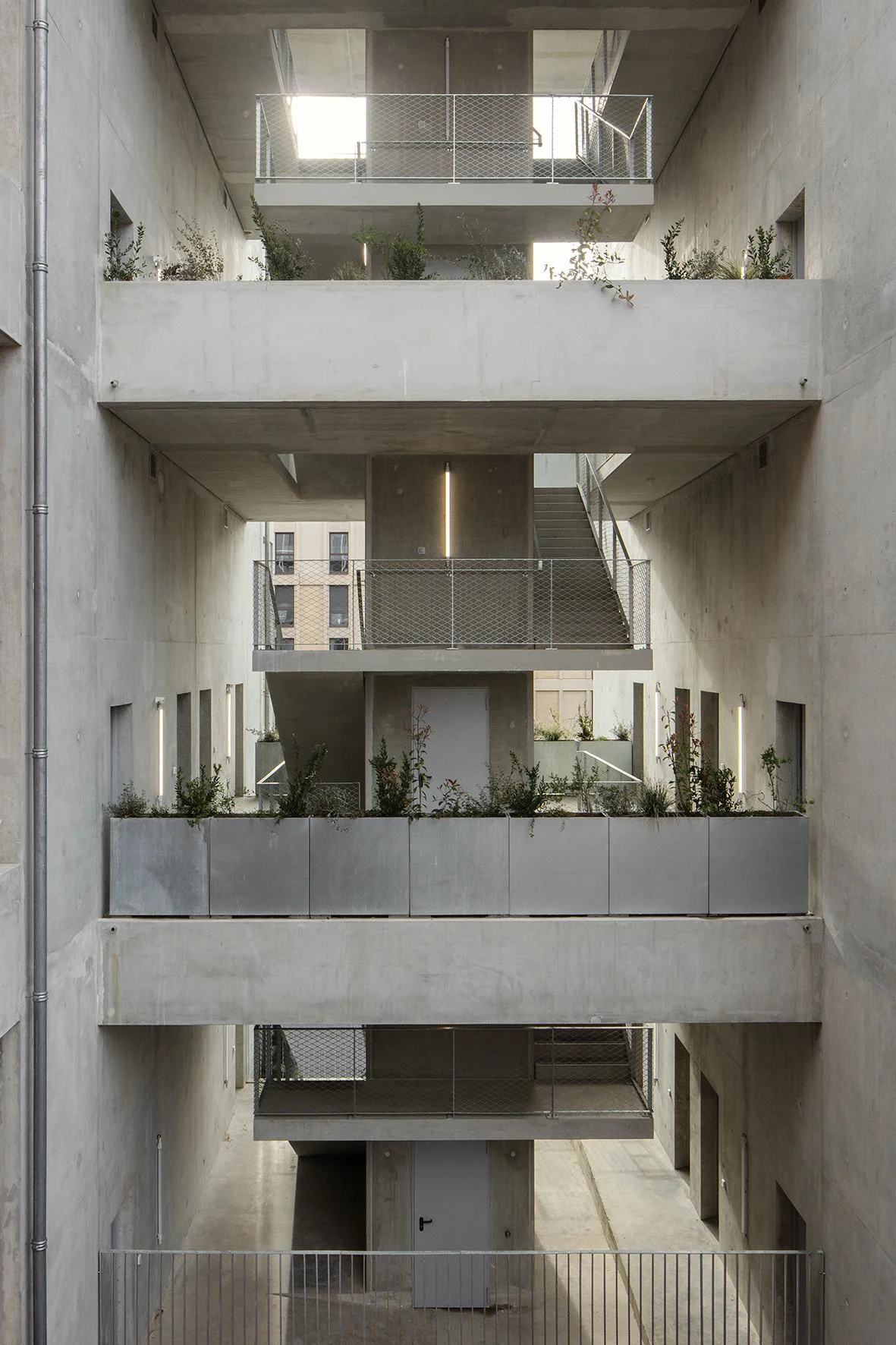 Vue intérieure du projet “Les Volumes Capables” (Bordeaux) par A6A – des volumes en béton brut à approprier et mezzanines modulables. Image © Agnès Clotis, via afasia.