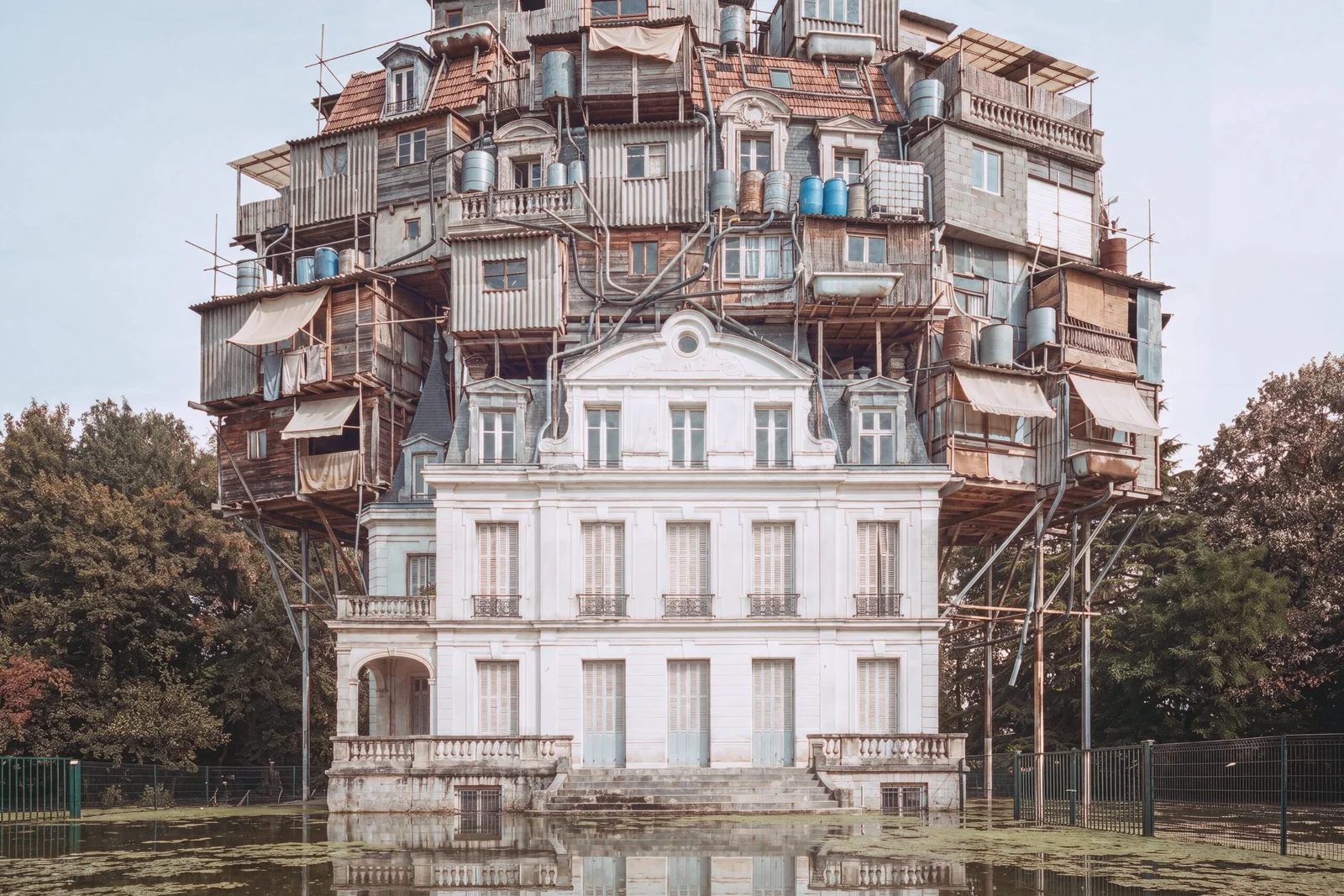 Un château du XIXe siècle intact surmonté de huit niveaux d'auto-construction et de dizaines de cuves à eau, le sol entièrement noyé sous une eau verte.